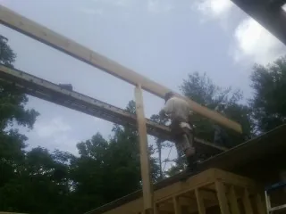 Carpenter setting a ridge beam over a new addition frame — Ice Dam Removal by Roofing Brothers in Sullivan