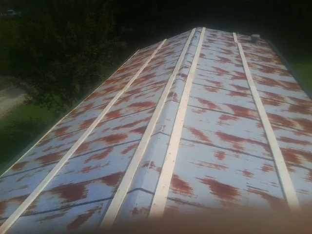 Rusted metal roof panels with new wood purlins before replacement — Storm Damage Roof Repair in Sullivan by Roofing Brothers